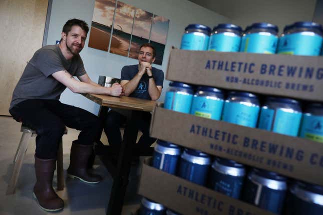 Le fondateur de l’entreprise, Bill Shufelt (à droite) et le brasseur en chef John Walker (à gauche) sont assis dans la brasserie sans alcool et l’usine de production d’Athletic Brewing à Stratford, Connecticut. 