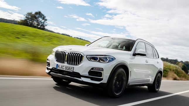 A white BMW crossover driving on a highway. 