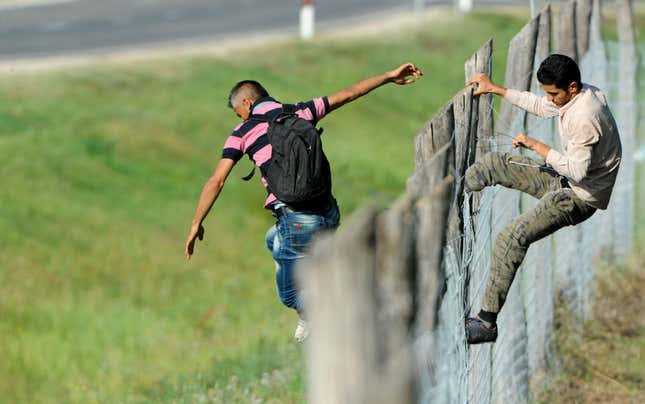 Image for article titled Photos: Fed up with the trains, migrants begin a long march down the highway in Hungary
