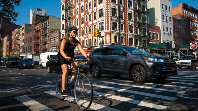 A cyclist rides with morning traffic on the Lower East Side on July 30, 2019 in New York City.