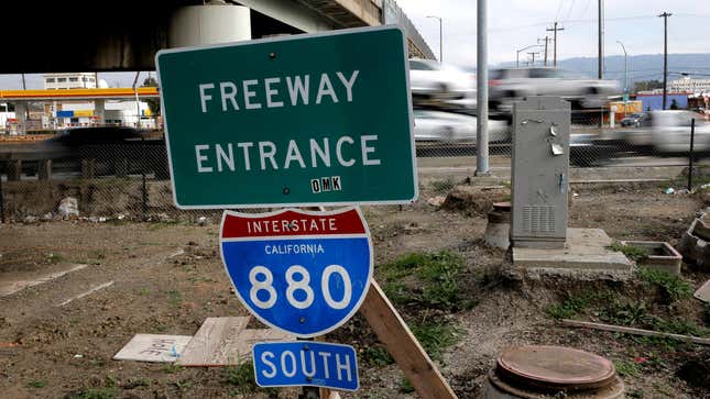 A highway sign reading "freeway entrance" above an interstate marker for I-800 sits in front of a busy freeway scene