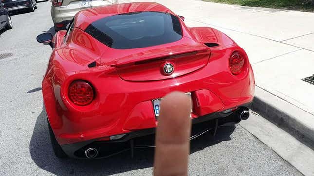 Un doigt bloquant une plaque d’immatriculation sur une Alfa Romeo 4C