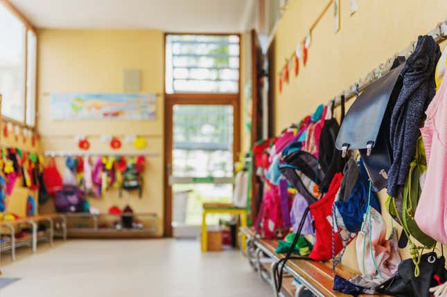 Empty hallway in the school, backpacks, and bags on hooks, bright recreation room