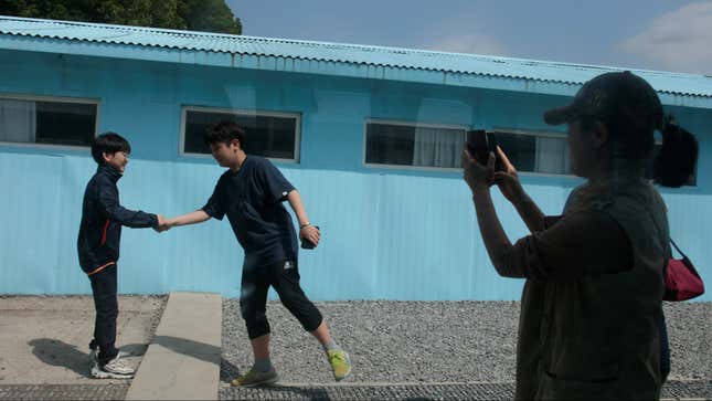 Two boys shake hands at the replica of the truce village of Panmunjom at a movie studio in Namyangju, South Korea.