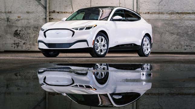 A white mach e parked in a garage in front of a reflective puddle