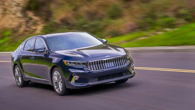 A photo of a Kia Cadenza sedan driving on a highway. 