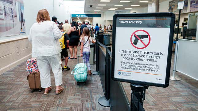 A photo of a "no guns" sign at a TSA checkpoint. 