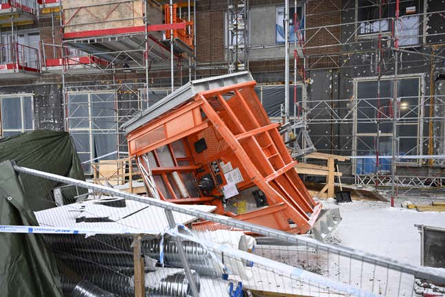 An elevator mounted on the outside of a unfinished building is seen a day after it plummeted 20 meters (66 feet) to the ground in a Stockholm suburb, Sweden, Tuesday Dec. 12, 2023. A Swedish prosecutor said Wednesday that a preliminary investigation into the crash of a construction site elevator that killed five people has been expanded to include two more possible workplace violations. (Fredrik Sandberg/TT News Agency via AP)