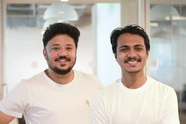 close up of two men wearing white t shirts standing beside each other