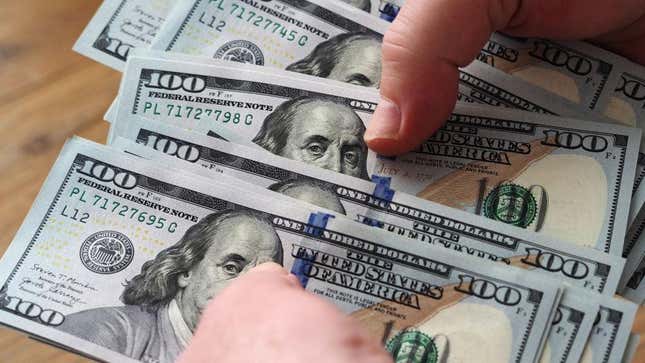 Person counting out hundred dollar bills