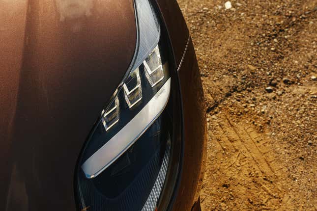 Headlight detail of a brown Aston Martin DB12 Volante