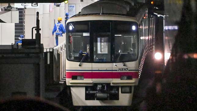 A Keio Line subway train brought to a stop on the train tracks. 