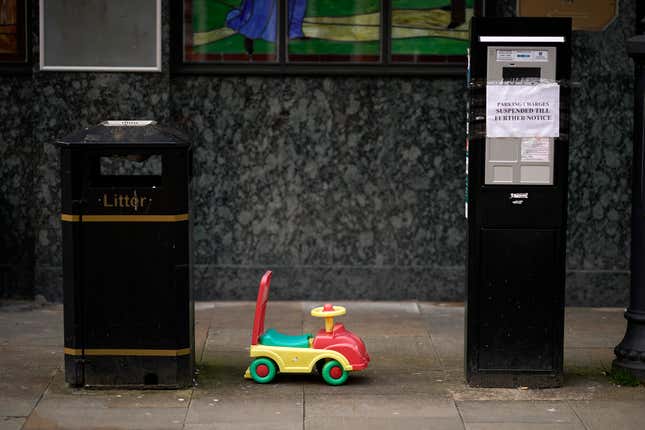  Ein weggeworfenes Kinderspielzeugauto steht neben einem Parkautomaten mit dem Schild „Parkgebühren bis auf Weiteres ausgesetzt“