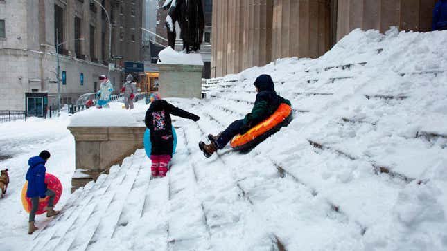 People playing as snow falls in Wall Street during a winter storm on February 1, 2021 in New York City. 