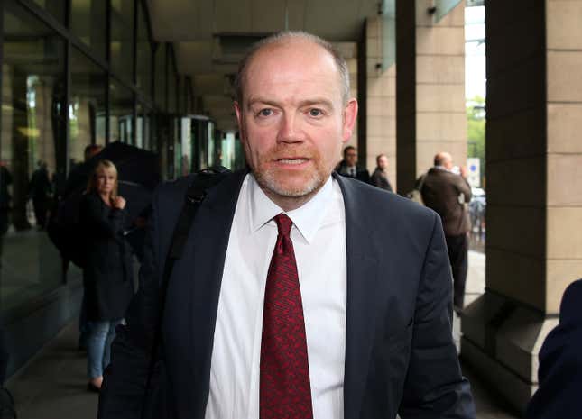 Former BBC director general Mark Thompson, wearing a suit and red tie, leaves Portcullis House in London.