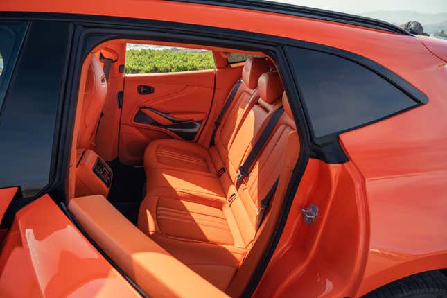 Rear seat of an orange 2025 Aston Martin DBX707