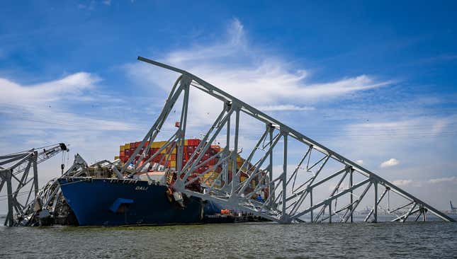 A photo of the Dali ship under the remnants of a bridge. 