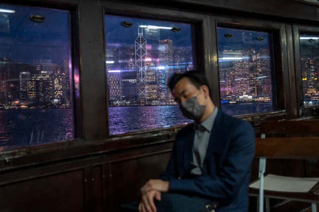 FILE - The city skyline is seen as a man naps on the Star Ferry in Hong Kong, on Oct. 19, 2022. The exodus of tens of thousands of professionals from Hong Kong triggered by Beijing&#39;s crackdown on its civil liberties is being offset by new arrivals: mainland Chinese keen to move to the former British colony. (AP Photo/Vernon Yuen, File)