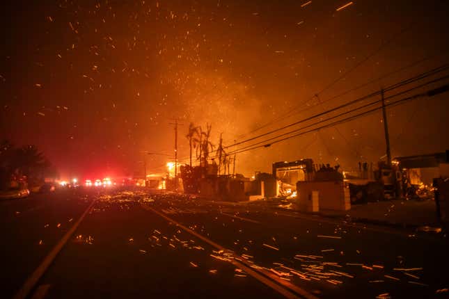 Starke Winde verwehen Glut, als das Palisades-Feuer am 8. Januar 2025 in Los Angeles, Kalifornien, während eines heftigen Sturms Häuser am Pacific Coast Highway niederbrennt.