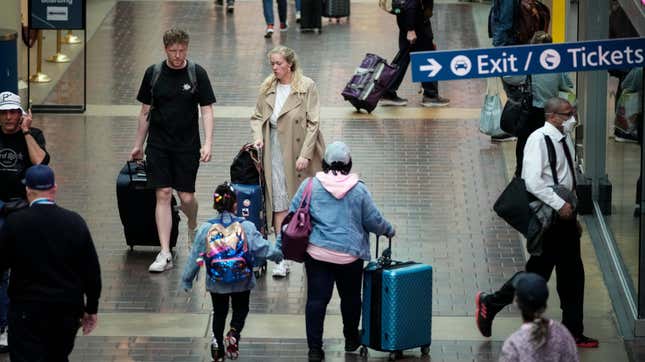 Travelers with luggage walk along the concourse on their way to board an Amtrak train at Union Station on May 27, 2022 in Washington, DC.