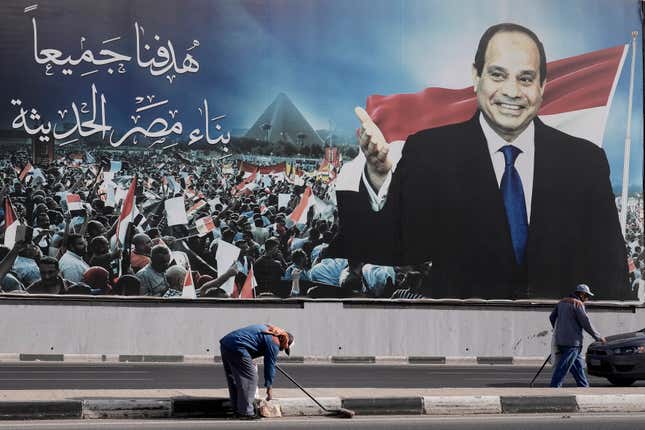 Workers clean the street under a billboard supporting Egyptian President Abdel Fattah el-Sissi for the presidential elections, in Cairo, Egypt, Sunday, Dec. 10, 2023. Egyptians began voting Sunday in a presidential election in which President Abdel Fattah el-Sissi, who faces no serious challenger, is certain to win another term, keeping him in power until 2030. Arabic reads,&quot; our target is to build modern Egypt.&quot; (AP Photo/Amr Nabil)