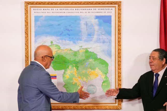 National Assembly President Jorge Rodriguez, left, and Chairman of the Special Commission for the Defense of Guyana Essequibo Hermann Escarra, shake hands after unveiling Venezuela&#39;s new map that includes the Essequibo territory, a swath of land that is administered and controlled by Guyana but claimed by Venezuela, in Caracas, Venezuela, Friday, Dec. 8, 2023. (AP Photo/Matias Delacroix)