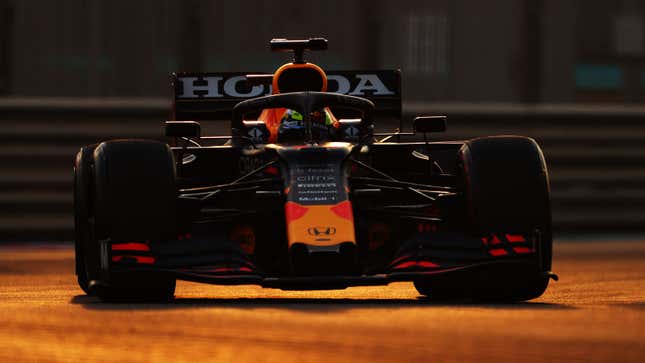 Sergio Perez racing his 2021 Red Bull F1 car at sunset. 