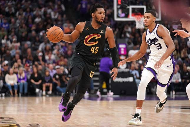 Nov 13, 2023; Sacramento, California, USA; Cleveland Cavaliers guard Donovan Mitchell (45) dribbles the ball next to Sacramento Kings forward Keegan Murray (13) in the second quarter at the Golden 1 Center.