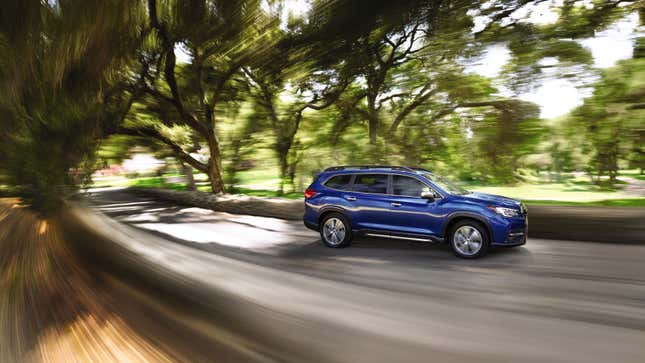 A blue Subaru SUV driving on a country road 