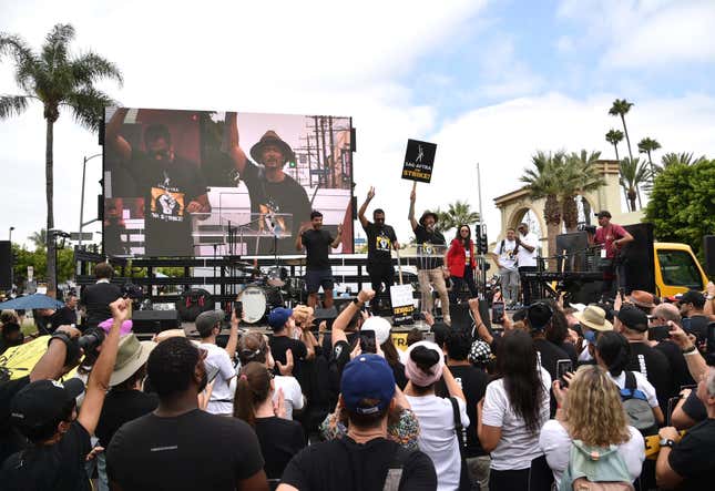 Kal Penn, center left, and John Cho, center right, speak during a rally outside Paramount Pictures Studio on Wednesday, Sept. 13, 2023, in Los Angeles. The film and television industries remain paralyzed by Hollywood&#39;s dual actors and screenwriters strikes. (Photo by Richard Shotwell/Invision/AP)