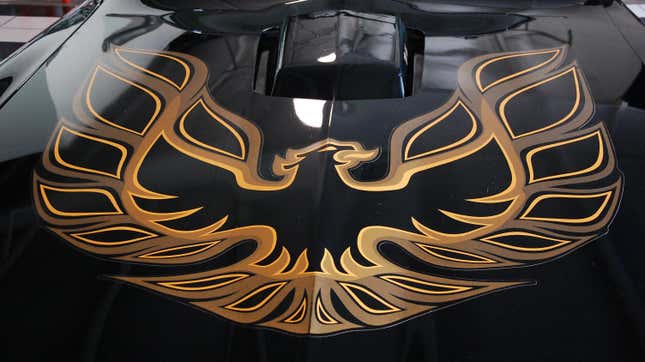 Una foto del capó de un Firebird negro con un Firebird dorado encima