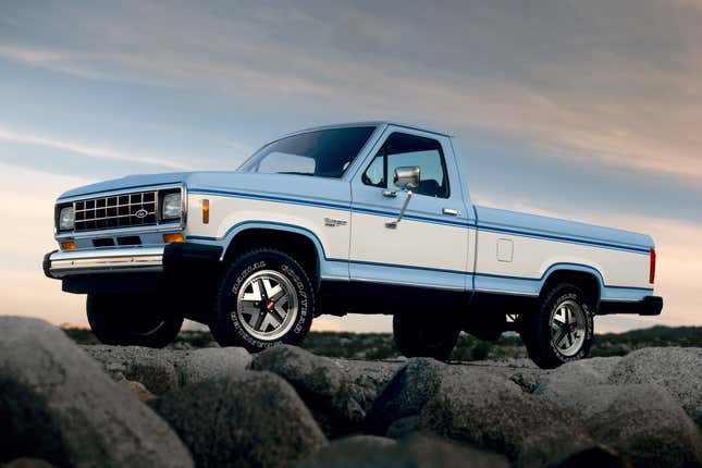 Front-quarter view of a blue-and-white first-generation Ford Ranger on a rocky surface.