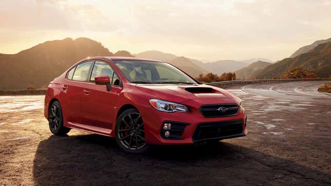 A photo of a red Subaru WRX sedan at sunset