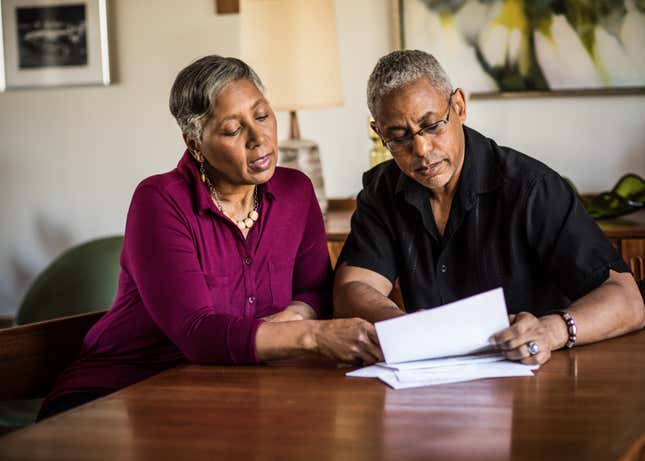 Black family looking at bills