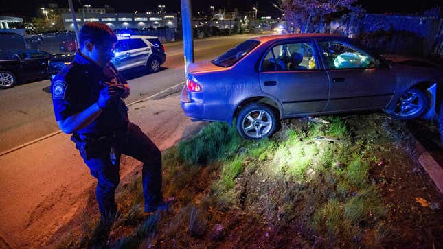 Officer Daniel Arteaga inspects a car crash in Chelsea, Massachusetts on May 1, 2021. 