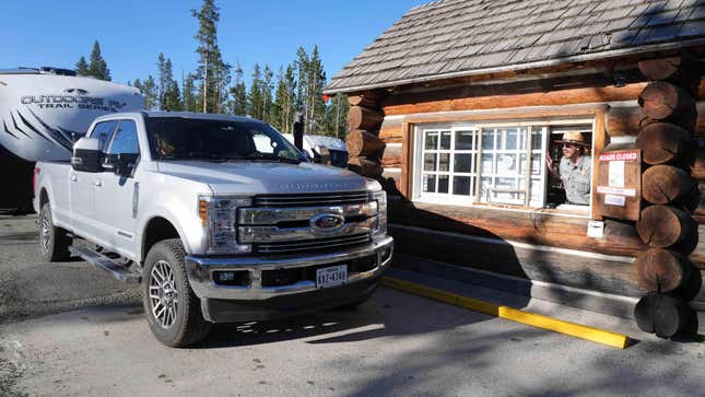 Large Ford truck hauling a camper waits to be admitted to Yellowstone National Park in Wyoming.