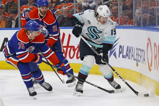 Nov 15, 2023; Edmonton, Alberta, CAN; Seattle Kraken forward Jared McCann (19) and Edmonton Oilers forward Ryan McLeod (71) battle along the boards for a loose puck during the second period at Rogers Place.