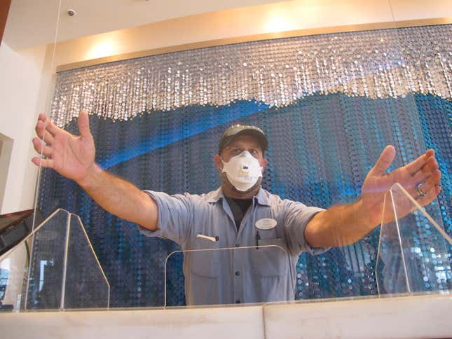 A worker installs a plexiglass barrier at a reservations desk at the Ocean Casino Resort in Atlantic City N.J. on June 3, 2020, about a month before it was allowed to reopen during the early stage of the COVID-19 outbreak. The New Jersey Supreme Court is expected to hear arguments, Wednesday, Sept. 27, 2023, in a case involving whether insurance companies were correct in denying payouts to the casino for business losses during the state-mandated closure in 2020. (AP Photo/Wayne Parry)