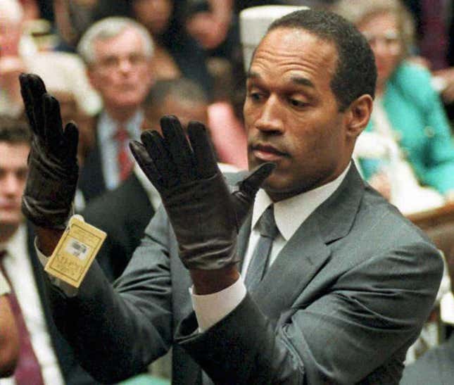 Los Angeles, UNITED STATES: (FILES): This 21 June 1995 file photo shows former US football player and actor O.J. Simpson looking at a new pair of Aris extra-large gloves that prosecutors had him put on during his double-murder trial in Los Angeles. Media tycoon Rupert Murdoch announced 20 November 2006 the cancellation of a controversial book and television interview involving O.J. Simpson being planned by his News Corp company.