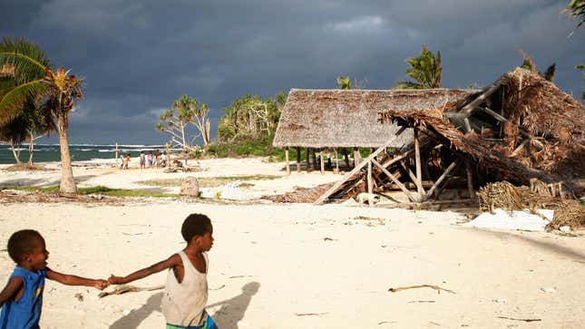 In this Saturday, May 30, 2015, photo, children play on the beach in the town of Takara, on Efate Island, Vanuatu. The town was damaged during Cyclone Pam. 