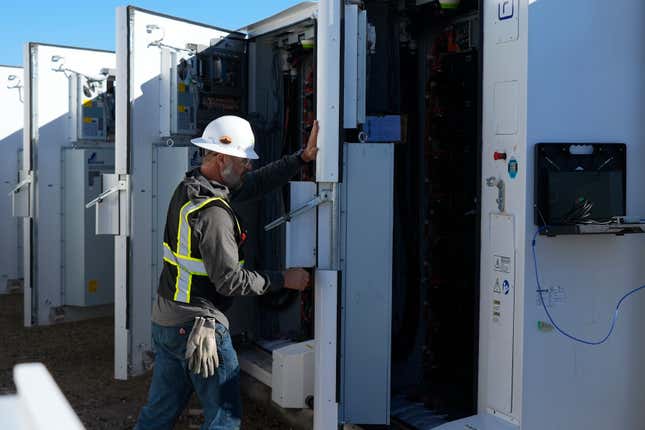 A worker does checks on battery storage pods at Orsted&#39;s Eleven Mile Solar Center lithium-ion battery storage energy facility Thursday, Feb. 29, 2024, in Coolidge, Ariz. Batteries allow renewables to replace fossil fuels like oil, gas and coal, while keeping a steady flow of power when sources like wind and solar are not producing. (AP Photo/Ross D. Franklin)