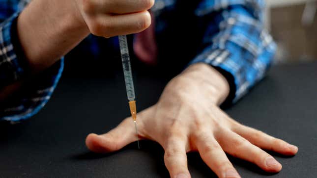 Image for article titled Bored Vaccination Worker Spends Afternoon With No Patients Stabbing Syringe Between Fingers