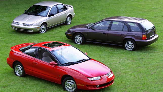 A photo of three Saturn S Series cars parked in a field. 