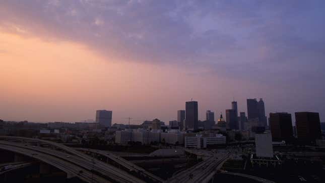 A photo of the skyline in Atlanta with the sun setting on the left. 