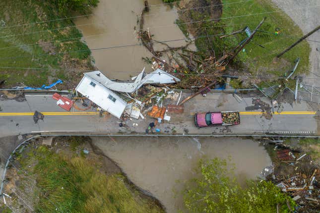 People work to clear a house from a bridge near the Whitesburg Recycling  Center in Letcher County, Ky., on Friday, July 29, 2022.