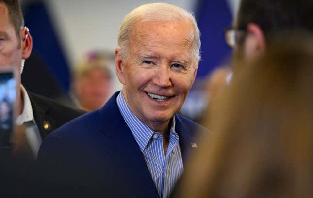 close up of joe biden smiling surrounded by people