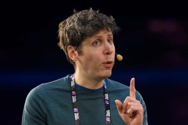 Sam Altman wearing a mic and dark teal shirt with a lanyard that says tech week speaking with his left hand pointer up