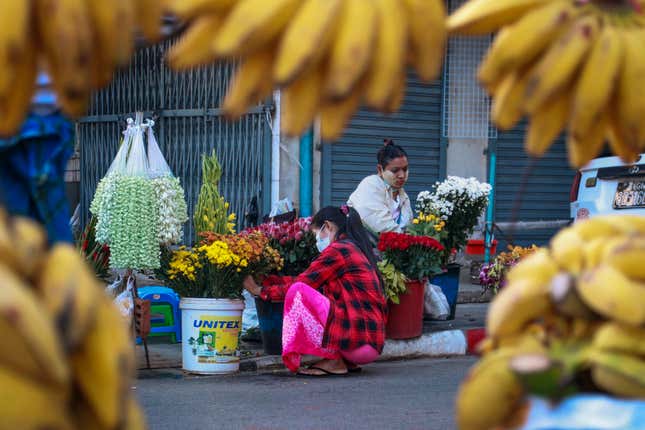 FILE - Woman arrange flowers at a street market in Yangon, Myanmar, on Feb. 2, 2021. Myanmar was a rising star in Southeast Asia before its military seized power three years ago in a takeover that has brought civil strife and a tightening vise of sanctions, undoing years of progress and leaving the economy 10% smaller than it was in 2019. (AP Photo/Thein Zaw, File)