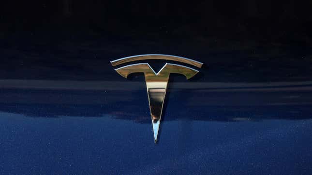 The Tesla logo is displayed on a brand new Tesla car at a Tesla dealership on October 18, 2023 in Corte Madera, California