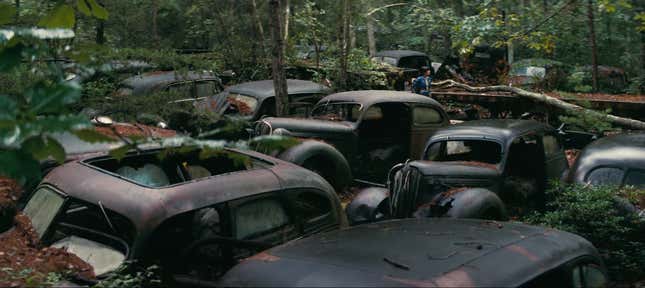 Multiple abandon cars rusting in the woods
